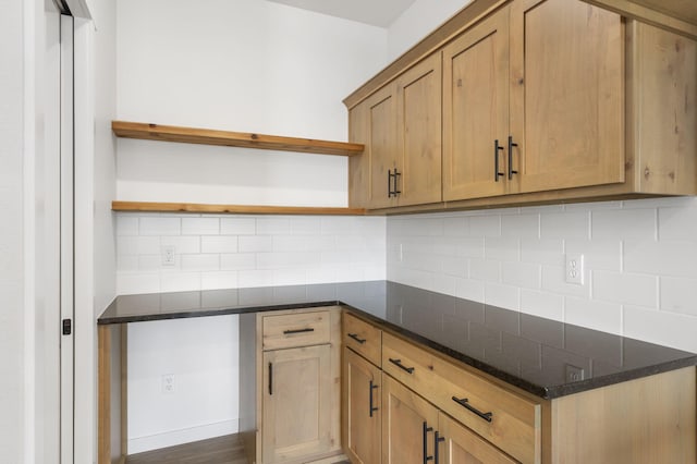 kitchen with tasteful backsplash and dark stone countertops