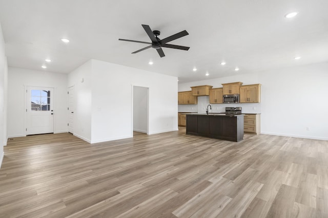 kitchen featuring light hardwood / wood-style flooring, an island with sink, ceiling fan, and appliances with stainless steel finishes