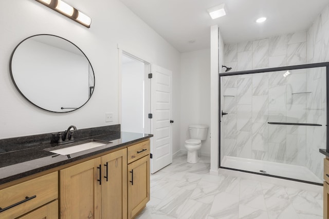 bathroom featuring vanity, a shower with shower door, and toilet