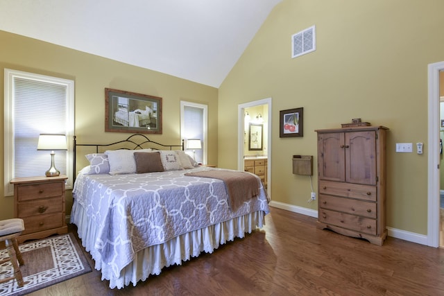 bedroom featuring lofted ceiling, wood-type flooring, and ensuite bath