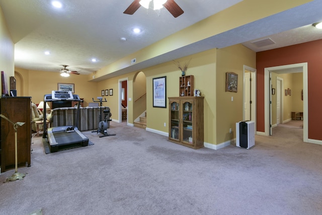 workout room with carpet flooring, ceiling fan, and a textured ceiling