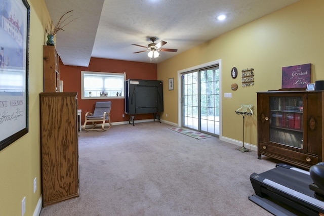 sitting room with ceiling fan, light colored carpet, a healthy amount of sunlight, and a textured ceiling