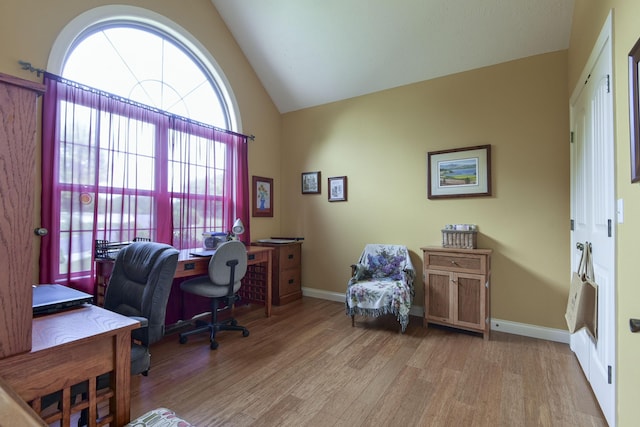 office with vaulted ceiling and light hardwood / wood-style flooring