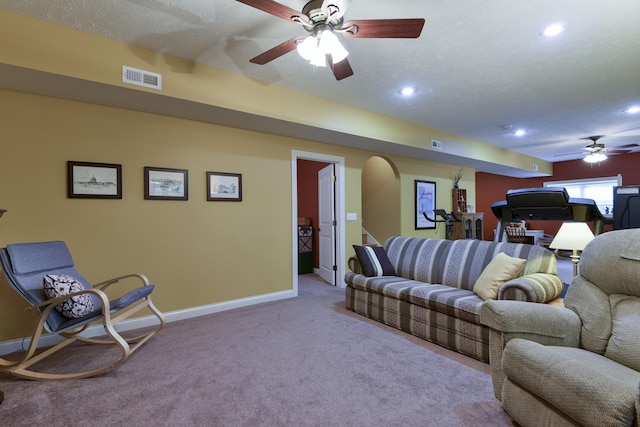 living room featuring a textured ceiling, light colored carpet, and ceiling fan