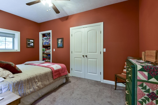 carpeted bedroom with a textured ceiling, a closet, and ceiling fan