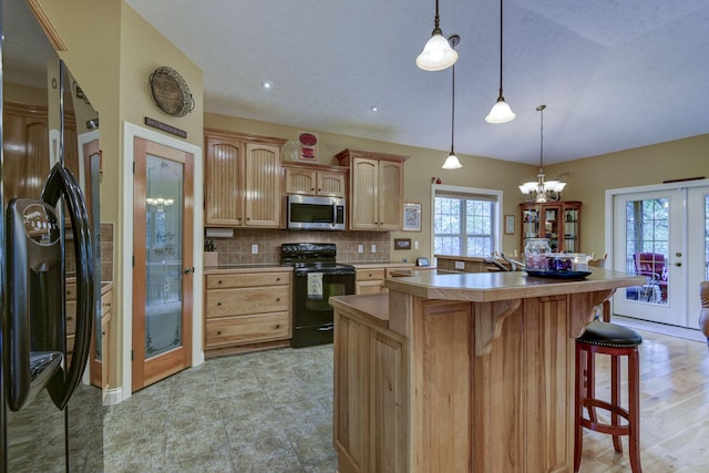 kitchen with a notable chandelier, hanging light fixtures, stainless steel appliances, and light brown cabinetry