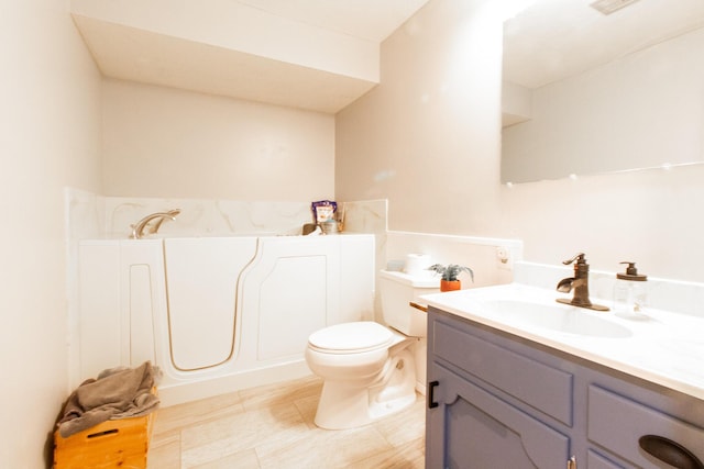 bathroom with a bathing tub, vanity, and toilet