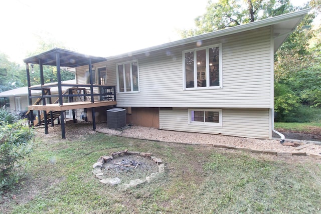 back of property with central AC unit and a deck