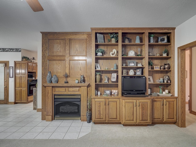 tiled living room with ceiling fan and a textured ceiling