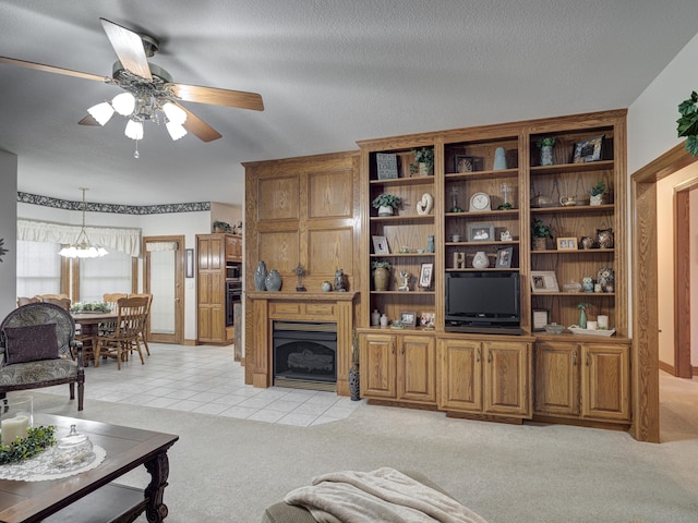 living room featuring a textured ceiling, ceiling fan with notable chandelier, and light colored carpet