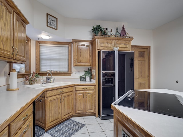 kitchen featuring black appliances, light tile patterned flooring, and sink