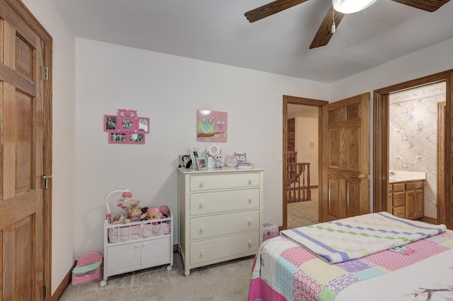 bedroom with light carpet, ensuite bathroom, and ceiling fan