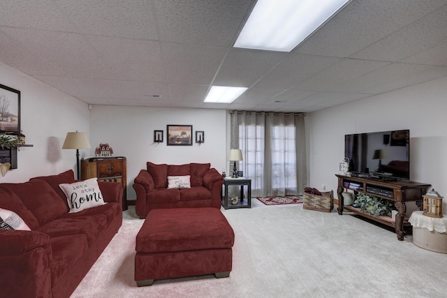 carpeted living room featuring a drop ceiling