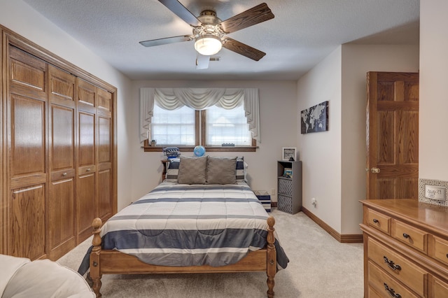 carpeted bedroom featuring a textured ceiling, a closet, and ceiling fan