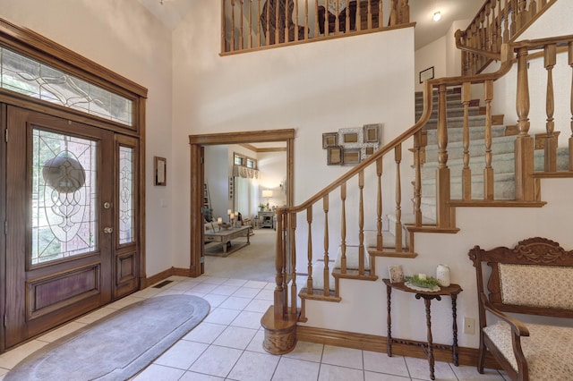 foyer entrance with light tile patterned floors and a high ceiling