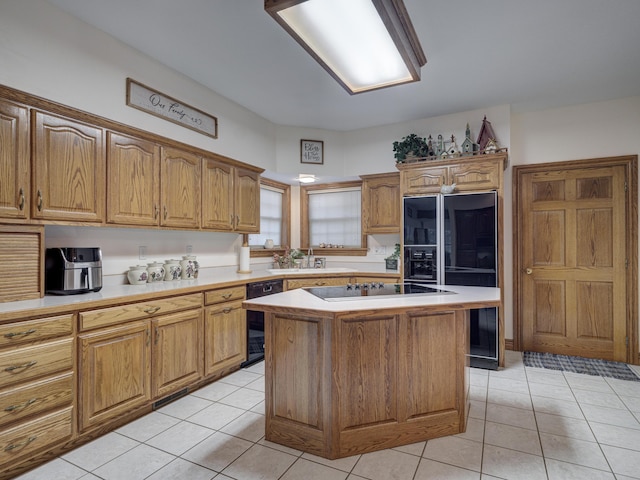 kitchen with light tile patterned flooring, sink, a kitchen island, and black appliances