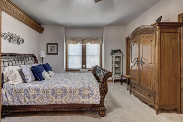 bedroom with ceiling fan, carpet, and a textured ceiling