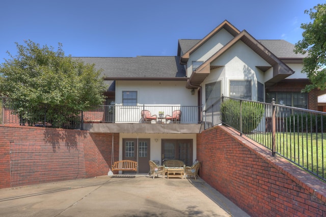 view of front of house featuring a balcony and a patio area