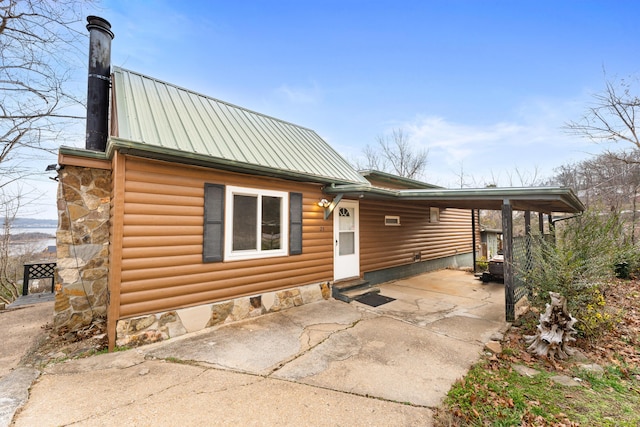 29 Adams Ln, Blue Eye, MO 65611 - view of front of house featuring concrete driveway, a metal roof, log veneer siding, and a patio area