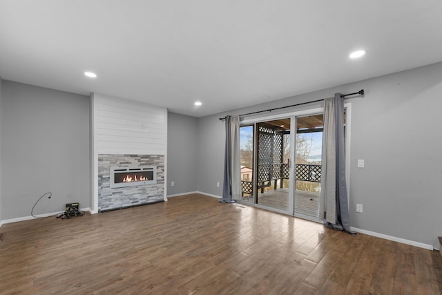 unfurnished living room featuring a tile fireplace and hardwood / wood-style flooring