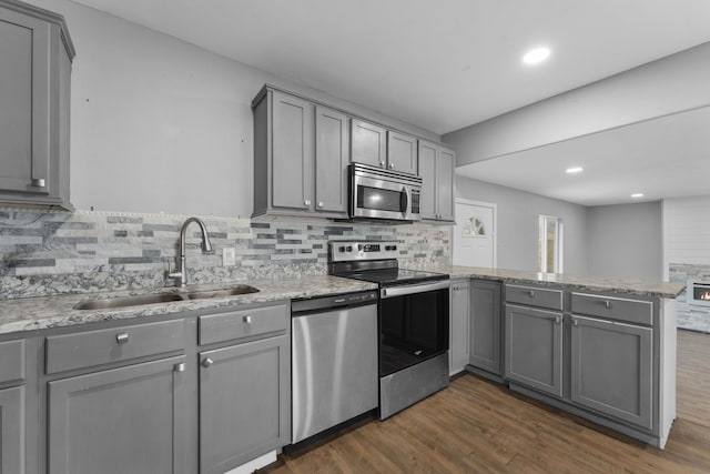 29 Adams Ln, Blue Eye, MO 65611 - kitchen featuring stainless steel appliances, gray cabinetry, a peninsula, dark wood-style flooring, and decorative backsplash