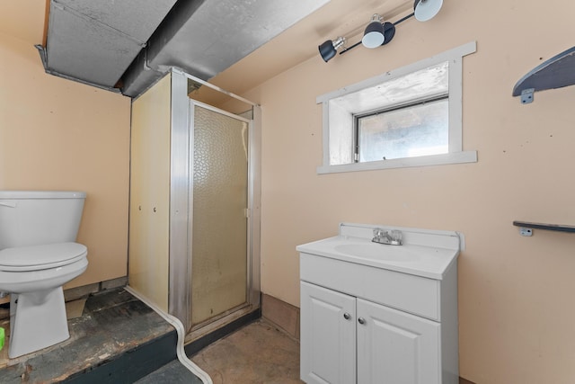 bathroom featuring concrete floors, vanity, a shower with shower door, and toilet