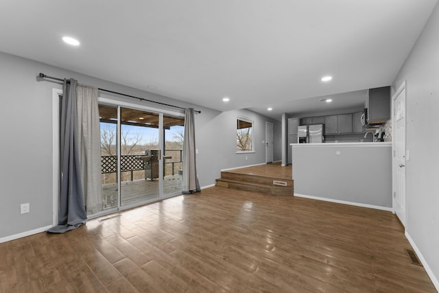 unfurnished living room with dark hardwood / wood-style floors and sink