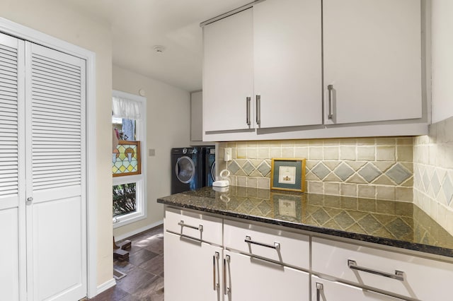 kitchen with white cabinets, decorative backsplash, washer / clothes dryer, and dark stone counters