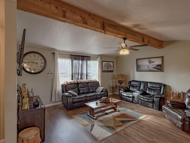 living room featuring dark hardwood / wood-style floors, beam ceiling, a textured ceiling, and ceiling fan