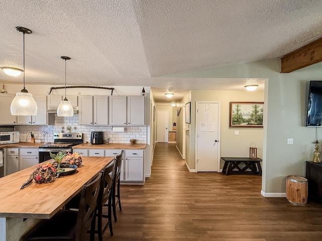 kitchen with wooden counters, stainless steel electric stove, hanging light fixtures, vaulted ceiling, and decorative backsplash