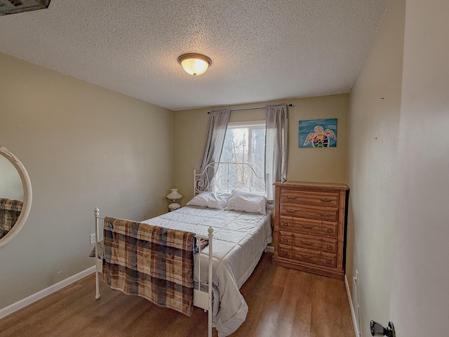 bedroom with hardwood / wood-style floors and a textured ceiling