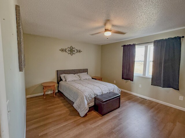bedroom featuring a textured ceiling, light hardwood / wood-style flooring, and ceiling fan