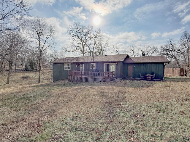 ranch-style house featuring a front yard and a wooden deck