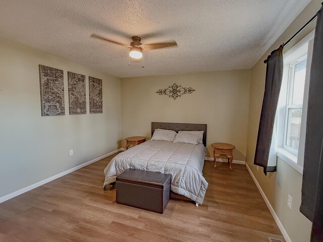 bedroom featuring multiple windows, a textured ceiling, and ceiling fan