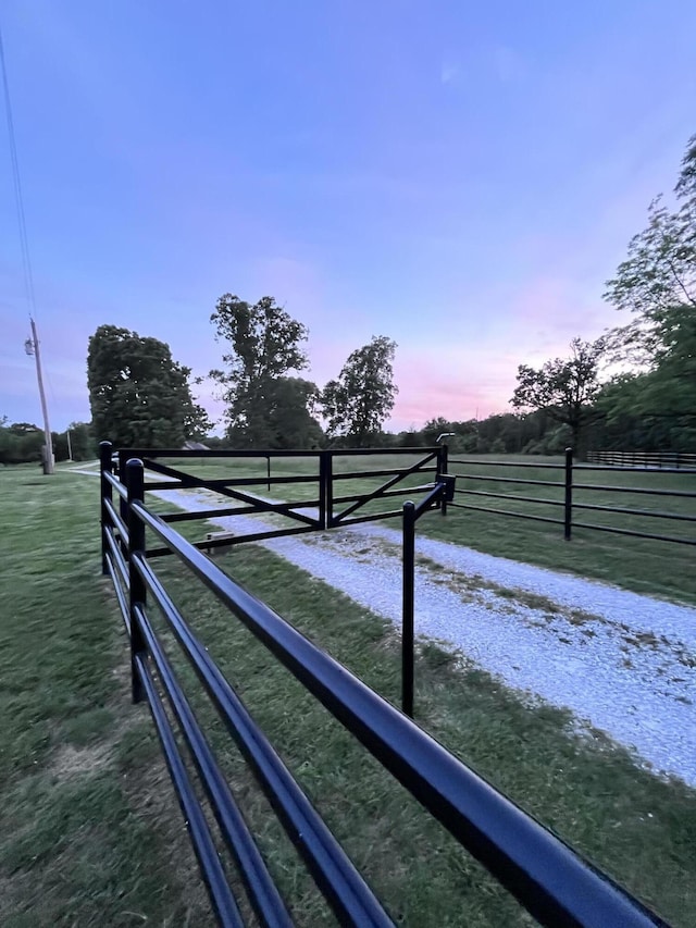 gate at dusk featuring a rural view