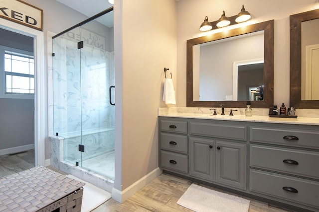 bathroom with vanity, an enclosed shower, and wood-type flooring