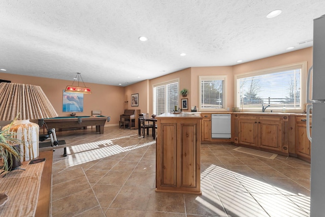 kitchen with pool table, white dishwasher, tile patterned floors, hanging light fixtures, and sink