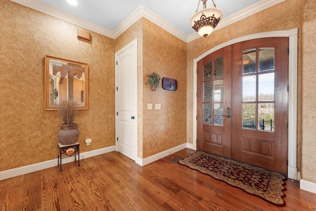 entryway with hardwood / wood-style floors, ornamental molding, and french doors