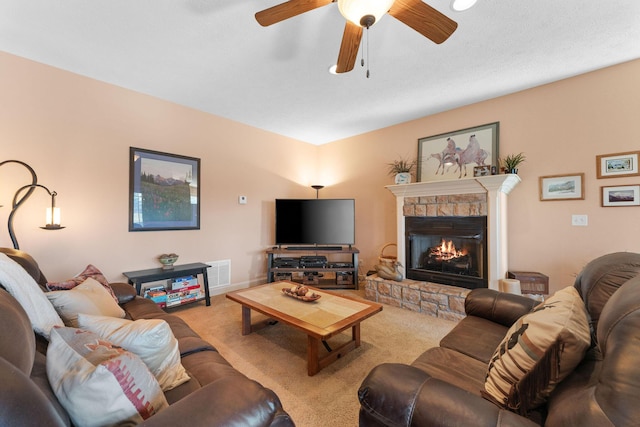 carpeted living room featuring ceiling fan and a fireplace