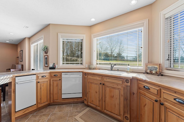 kitchen featuring kitchen peninsula, sink, white dishwasher, and beverage cooler