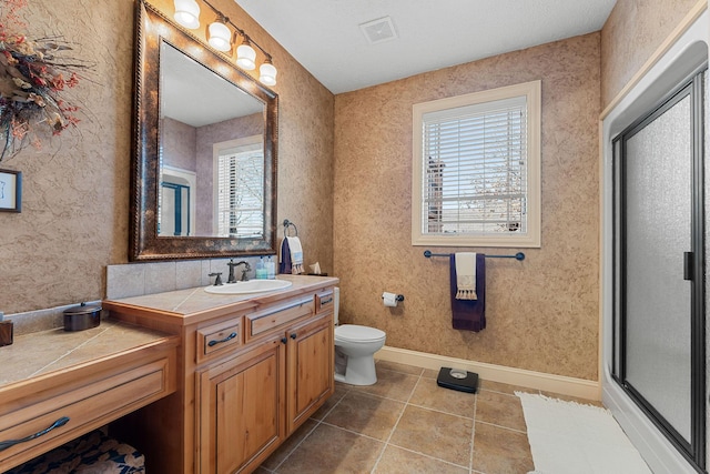 bathroom with tile patterned flooring, plenty of natural light, vanity, and an enclosed shower