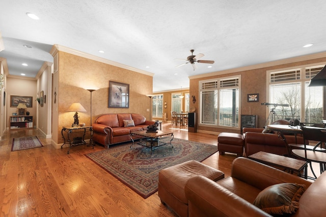 living room with a textured ceiling, ceiling fan, crown molding, and light hardwood / wood-style floors