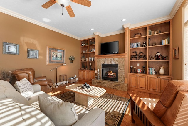 living room with ceiling fan, a fireplace, ornamental molding, and hardwood / wood-style floors