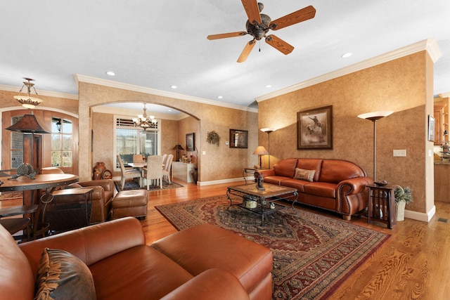 living room featuring ceiling fan with notable chandelier, crown molding, and light hardwood / wood-style floors