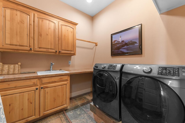 laundry area featuring washer and clothes dryer, sink, and cabinets