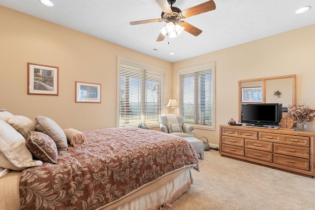 carpeted bedroom featuring ceiling fan and a textured ceiling