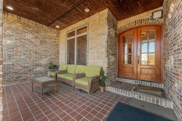 view of exterior entry with french doors and a porch