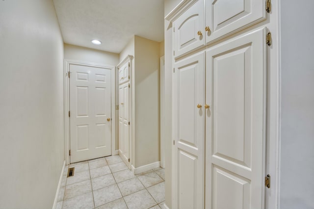 hall featuring light tile patterned floors