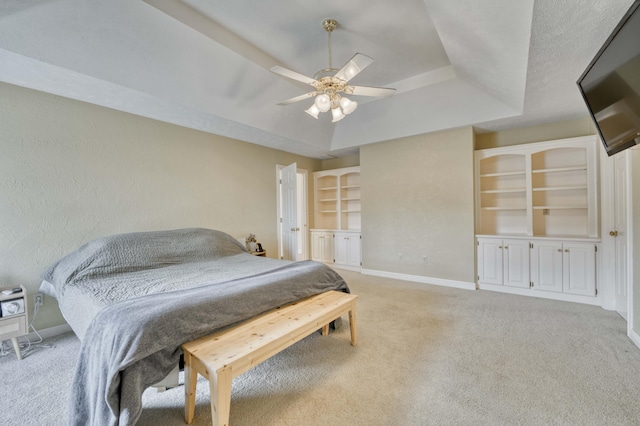 bedroom with ceiling fan, a raised ceiling, and light carpet