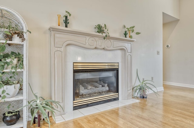 interior details featuring hardwood / wood-style flooring and a tiled fireplace